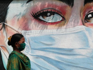 އިންޑިޔާގެ މުމްބާއީގައި މަގެއްގެ މަތީގައި އަންހެނަކު މާސްކު އަޅައިގެން ހިނގާފައިދަނީ