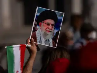 އެމެރިކާ އާއި އިޒްރޭލްގެ ހަމަލާ ތަކުގައި އަވަހާރަ ކޮށްލާފައިވާ އީރާންގެ ކުރީގެ ރޫހާނީ ލީޑަރު ޚާމަނާއީގެ ފޮޓެއް ހިފައިގެން މީހަކު