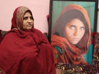 Sharbat Gula sits alongside the iconic image taken when she was a child refugee