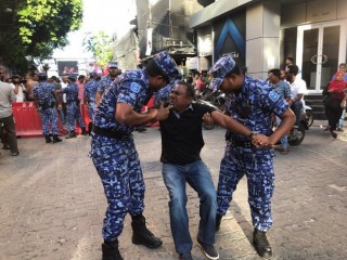 A man being taken away by police during a protest