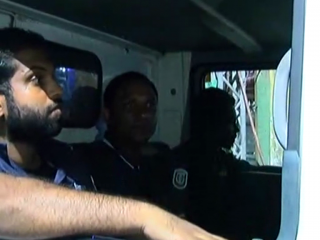 MP Saud Hussein being escorted away in a police vehicle 