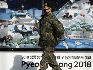 ދެކުނު ކޮރެއާގެ ޕިޔޮންގްޗެންގައި އޮންނަ ފިނި މޫސުމުގެ އޮލިމްޕިކްސްގެ ޕޯސްޓަރެއް ކައިރިން ދެކުނު ކޮރެއާގެ ސިފައިންގެ މީހަކު ހިނގާފައި ދަނީ