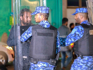 Riot police disperse a journalist