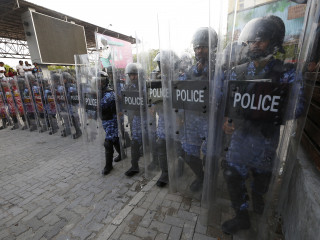 Officers of the Maldives Police Service in riot gear lined up to disperse a demonstration of protesters in capital city Malé