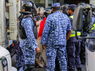 މުޒާހަރާއެއްގެ ތެރޭގައި ފުލުހުންތަކެއް، އަންހެނަކު ވަށާލައިގެން