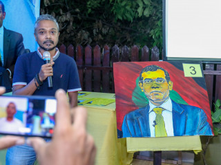 Artist Baachy with his painting of President Nasheed at Hangout Cafe\'