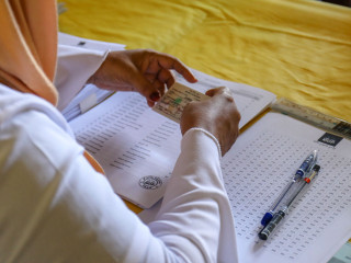 An administrative official referencing a voter\'s identification with the party registry