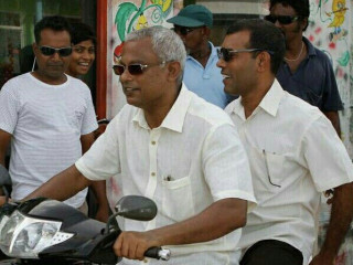 The opposition\'s presidential candidate Solih (l) riding a motorcycle with former President Nasheed