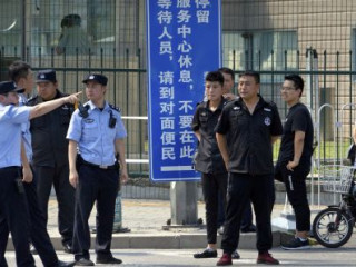 26 ޖުލައި 2018. ބެއިޖިންގައި ހުންނަ އެމެރިކާގެ އެމްބަސީގެ ކުރިމަތީގައި ސެކިއުރިޓީ އޮފިޝަލުންތަކެއް