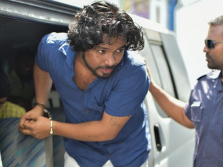 Lahiru Madushanka being escorted by prison officers to an earlier court hearing