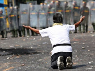 ކޮލަމްބިއާގެ ސަރަހައްދީ އިމުގެ ކައިރީ އެރުތިގެން ތިބި ސަފުތައް ކުރިމަތީ މީހަކު އާދޭސްކުރަނީ