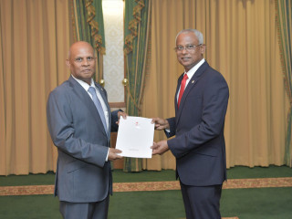 Hassan Sobir being presented with the letter of credence
