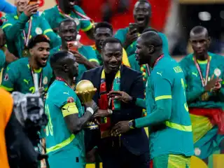 ސެނެގާލްގެ ކޯޗު ތިއޯ، އެ ޓީމުގެ ކުޅުންތެރިންނާ އެކު ޓްރޮފީ ހިފައިގެން އުފާ ފާޅު ކުރަނީ