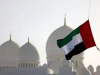 އަބޫދާބީގެ ޝައިހް ޒައިދު މިސްކިތުގެ ބޭރުގައި ޔޫއޭއީގެ ދިދަ ފެންނަ މަންޒަރެއް.