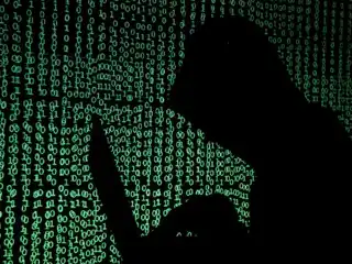 ހޫޑީއެއް އަޅައިގެން ހުރި މީހަކު ލެޕްޓޮޕް ހިފައިގެން ހުންނަ މަންޒަރެއް ކުރަހާފައި 