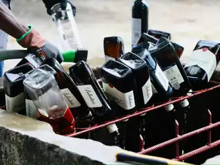Police destroy seized alcohol.