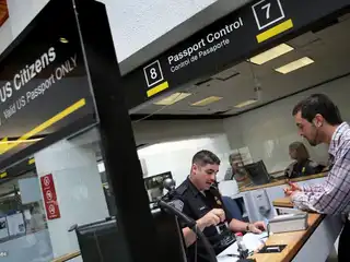 އެމެރިކާގެ މިއާމީ އިންޓަނޭޝަނަލް އެއާޕޯޓުގައި ކަސްޓަމްސް އެންޑް ބޯޑަރ ޕްރޮޓެކްޝަން އޮފިސަރަކު ޕާސްޕޯޓު ޗެކް ކުރަނީ