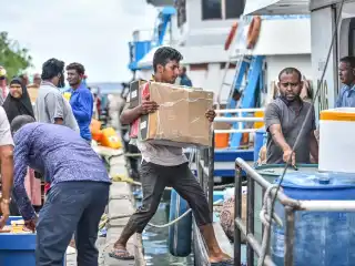 Goods to be transported to an island, being loaded onto a boat