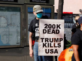 އެމެރިކާގައި ކުރިޔަށްދިޔަ މުޒާހަރާއެއްގައި މީހަކު ޕޯސްޓަރެއް ހިފައިގެން