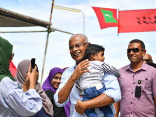 President Ibrahim Mohamed Solih with a child during a visit to an outlying atolls