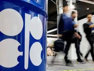 ޕެޓްރޯލިއަމް އެކްސްޕޯޓްކުރާ ގައުމުތަކުގެ ޖަމިއްޔާ، އޯޕެކްގެ ލޯގޯ ޖަހާފައިވާ ތެޔޮ ފީފާއެއްގެ މޮޑެލްއެއް ބަހައްޓާފައި ހުރި ސަރަހައްދަކުން ބަޔަކު ހިނގާފައި ދަނީ.