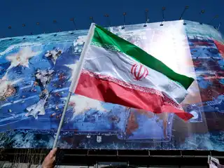 އީރާނުގެ ރޫހާނީ ލީޑަރު އަވަހާރަކޮށްލުމާ ގުޅިގެން ބޭއްވި ހިތާމައިގެ ރަސްމިއްޔާތެއްގެ ތެރެއިން، 2026 މާރިޗު 1 ވަނަ ދުވަހު އީރާނުގެ ތެހެރާންގެ އިންގިލާބީ މައިދާނުގައި ހުރި ބޮޑު ބެނާއެއްގެ ކުރިމަތިން އެ ގައުމުގެ ދިދަ ވިހުރާލަނީ. މި ބެނާއިން ފެންނަނީ ފާރިސީ ކަނޑުއޮޅީގައި އޮތް އެމެރިކާގެ މަނަވަރަކަށް އީރާނުން މިސައިލް ހަމަލާއެއް ދޭ މަންޒަރު. އީރާނުގެ ރޫހާނީ ލީޑަރު އަވަހާރަކޮށްލާފައިވަނީ އޭގެ އެއްދުވަސް ކުރިން، ފެބްރުއަރީ 28 ވަނަ ދުވަހު އޭނާ ދިރިއުޅުއްވާ ގެކޮޅަށް އިޒްރޭލާއި އެމެރިކާ ގުޅިގެން "އެޕިކް ފިއުރީ" ގެ ނަމުގައި ހިންގި ޚާއްސަ އޮޕަރޭޝަނެއްގައި.