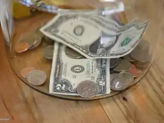 ފުޅިއެއްގައި ހުރި އެމެރިކާ ޑޮލަރާއި ފައިސާ ފޮތިތަކެއް.