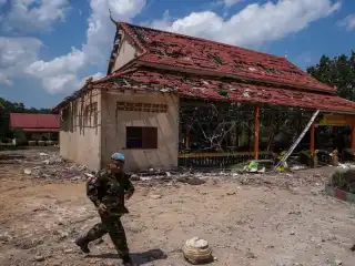 ކެމްބޯޑިއާގެ ސިފައިންގެ މީހަކު ބޮޑެތި ގެއްލުން ތަކެއް ލިބިފައިވާ އިމާރާތެއްގެ ކައިރިން ހިނގާފައި ދަނީ