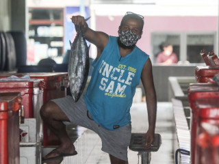 މާރުކޭޓުގައި މީހަކު މަހެއް ހިފަހައްޓާލައިގެން