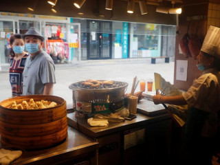 ބެއިޖިންގ ގައި މީހުން މާސްކު އަޅައިގެން ފިހާރައެއް ކައިރިން ދަނީ