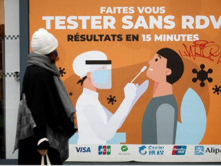 ފްރާންސްގެ ޕެރިސްގައި ކޮވިޑް-19 އަށް ޓެސްޓްކުރުމަށް ހަދާފައިވާ ބިލްބޯޑެއްގެ ކައިރިން މީހަކު ހިނގާފައިދަނީ