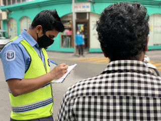 މާލެ ލޮކްޑައުން ކުރިއިރު މަގުމަތީގައި މަނާ ވަގުތުތަކުގައި ހަރަކާތްތެރިވާ މީހުން ބަލާ ފުލުހުން ނަން ނޯޓް ކުރަނީ