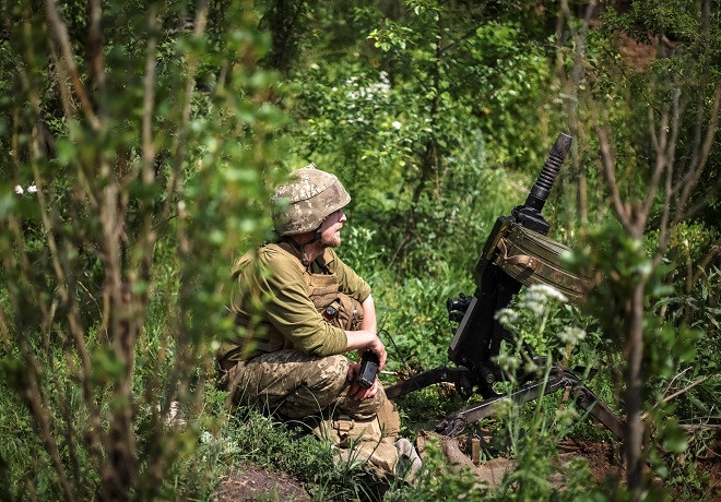 ޔޫކްރެއިންއަށް ރަޝިޔާއިން ދެމުންގެންދާ ހަމަލާގައި، ޔޫކްރެއިންގެ ސާވިސް މެމްބަރަކު ކުރީ ސަފުގައި އޮޓޮމެޓިކް ގްރެނޭޑް ލޯންޗަރެއް ކައިރީގައި އިށީންދެލައިގެން - ފޮޓޯ: ރޮއިޓަރސް