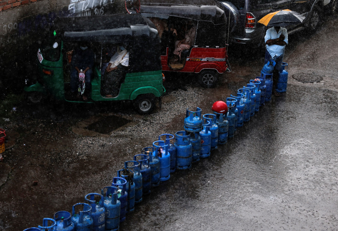 ލަންކާގެ އިގުތިސޯދީ ހީނަރުކަމުގެ ތެރޭގައި، ކޮލަމްބޯގެ ޑިސްޓްރިބިއުޓަރެއްގެ ކައިރީގައި ޑޮމެސްޓިކް ގޭސް ޓޭންކްތަކެއް ގަންނަން މީހަކު ކިއުގައި މަޑުކޮށްލައިގެން.
ފޮޓޯ: ރޮއިޓަރސް