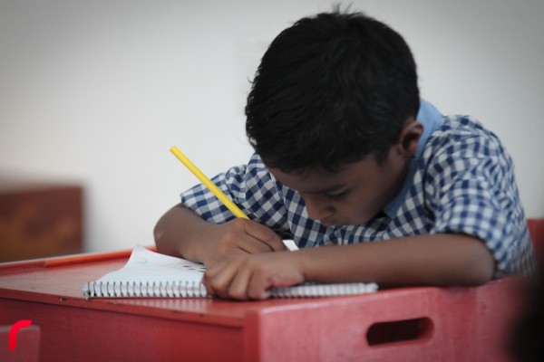 ކުޑަކުއްޖަކު ފޮތުގައި ކުރަހަނީ