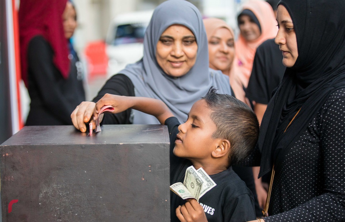 ސެޕްޓެމްބަރު 11، 2017: ރޮހިންޖާގެ މުސްލިމުންނަށް އެހީވުމަށް ރާއްޖެ ޓީވީއިން އިންތިޒާމްކޮށްގެން ހިންގި ޓެލެތޯންގައި ބެހެއްޓި ފަންޑް ފޮއްޓަށް މީހަކު ފައިސާ ހަދިޔާކުރަނީ، ޓެލެތޯން ނިންމާލިއިރު ހަތަރު މިލިއަނަށް ވުރެން ގިނަ ރުފިޔާ ވަނީ ލިބިފައި