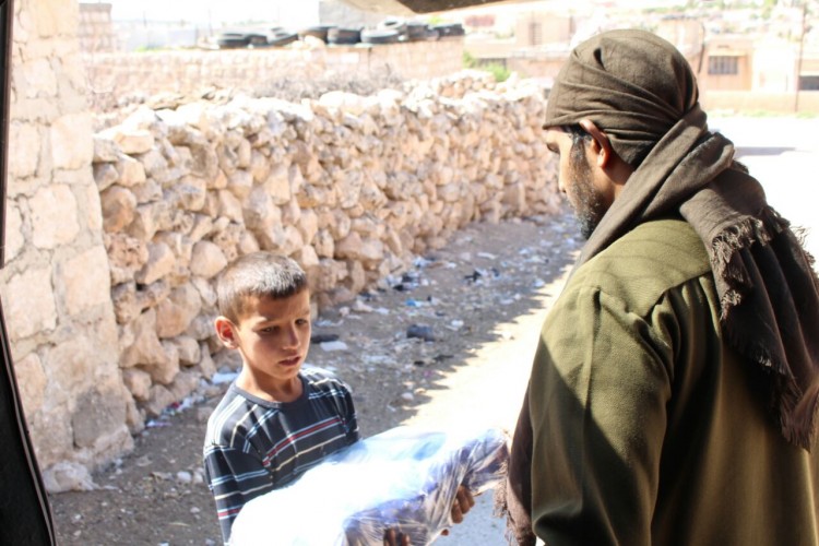 A combatant gives away a case of bottled water 