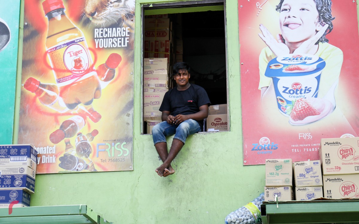 23 އޮކްޓޯބަރު 2017: ލޯކަލް މާރުކޭޓުން ސަރަހައްދުގައި ހުރި ފިހާރައެއްގައި މަސައްކަތްކުރާ ބިދޭސީއަކު މަޑުކޮށްލައިގެން. މުދާ ބޭލުމާއި، ބަރުކުރުމުގައި މި ސަރަހައްދުގައި ގިނަ އަދަދެއްގެ ބިދޭސީން މަސައްކަތް ކުރަމުންދާކަން ފާހަގަކުރެވޭ