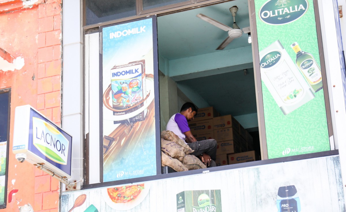 23 އޮކްޓޯބަރު 2017: ލޯކަލް މާރުކޭޓުން ސަރަހައްދުގައި ހުރި ފިހާރައެއްގައި މަސައްކަތްކުރާ ބިދޭސީއަކު މަޑުކޮށްލައިގެން. މުދާ ބޭލުމާއި، ބަރުކުރުމުގައި މި ސަރަހައްދުގައި ގިނަ އަދަދެއްގެ ބިދޭސީން މަސައްކަތް ކުރަމުންދާކަން ފާހަގަކުރެވޭ