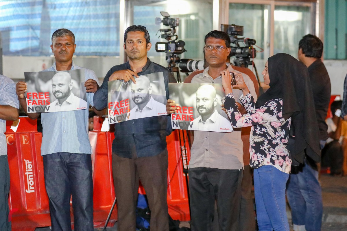 ޖެނުއަރީ 27، 2018: ރިޝްވަތު ދިންކަމުގެ ތުހުމަތުގައި ހައްޔަރުކޮށްފައިވާ ދިއްގަރު ދާއިރާގެ މެމްބަރު އަޙްމަދު ފާރިސް މައުމޫންގެ ބަންދުގެ މުއްދަތު ޖެހުމުގެ މަޖިލިސް ހިނގަމުން ދިޔައިރު، އިދިކޮޅު ކޯލިޝަންގެ މެމްބަރުން ކޯޓް އަސަރަހައްދުގައި ތިބެ ފާރިސް މިނިވަންކުރަން ގޮވާލައި ޝުއޫރު ފާޅުކުރަނީ -- ރާއްޖެ އެމްވީ ފޮޓޯ: މުހައްމަދު ޝަރުހާން