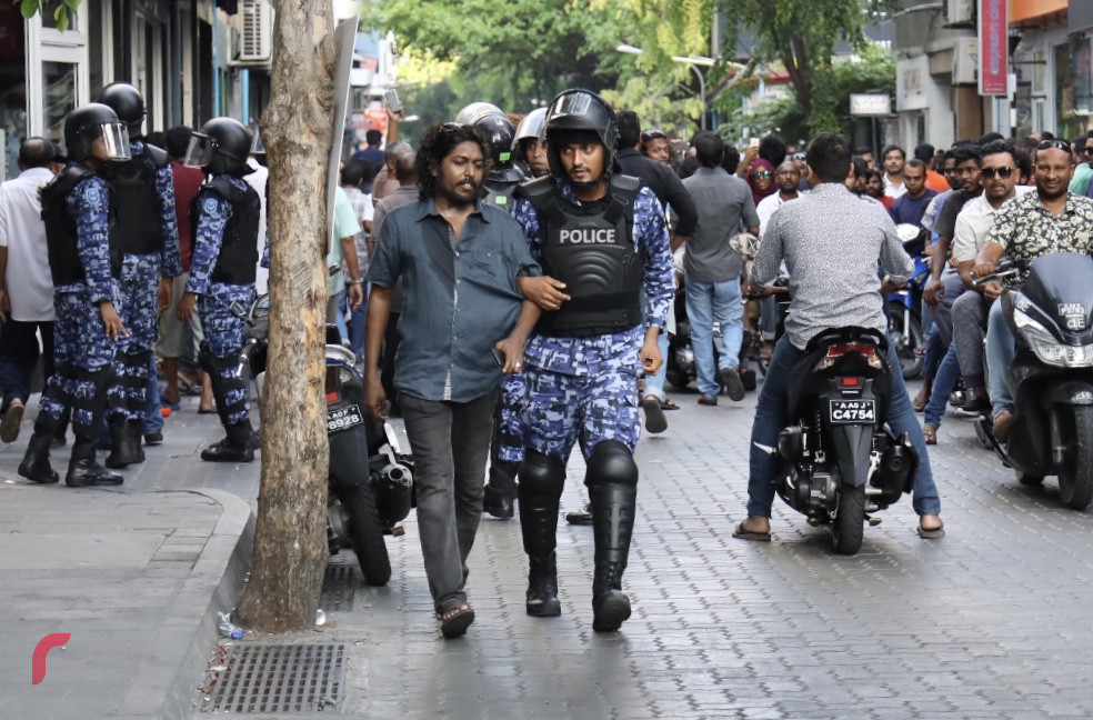 މާރޗް 2، 2018: ގުޅިފައިވާ އިއްތިހާދުން އިންތިޒާމްކޮށްގެން މާލޭގެ އެކި ސަރަހައްދުތަކުގައި ކުރިއަށްގެންދިޔަ މުޒާހަރާ ތަކުގެ ތެރެއިން ކުނޫޒު ސަރަހައްދުން މީހަކު ފޮނުވާލުމަށް އެސްއޯ ފުލުހަކު މަސައްކަތްކުރަނީ، ފުލުހުންވަނީ މުޒާހަރާ ރޫޅާލުމަށް ބާރުގެ ބޭނުންކޮށް ގިނަ އަދަދެއްގެ މީހުން ހައްޔަރުކޮށްފައި.-- ފޮޓޯ: މުހައްމަދު ޝަރުހާން