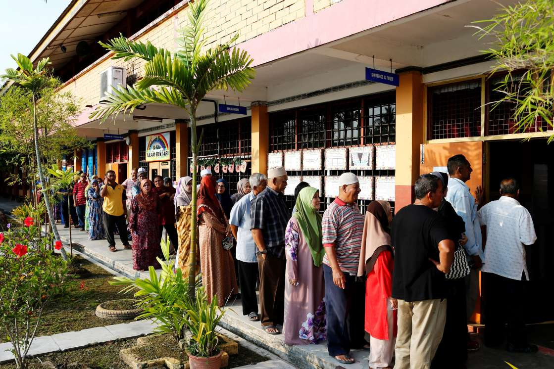 މެއި 9، 2018:މެލޭޝިއާގެ 14 ވަނަ އާންމު އިންތިހާބުގައި ވޯޓުލުމަށް މީހުން ވޯޓިން ބޫތްއެއްގައި ކިޔޫ ހަދާފައި