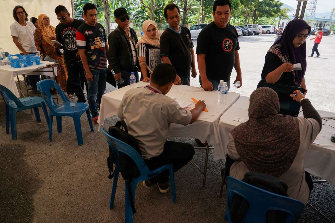 މެއި 9، 2018:މެލޭޝިއާގެ 14 ވަނަ އާންމު އިންތިހާބުގައި ވޯޓުލުމަށް މީހުން ވޯޓިން ބޫތްއެއްގައި ކިޔޫ ހަދާފައި