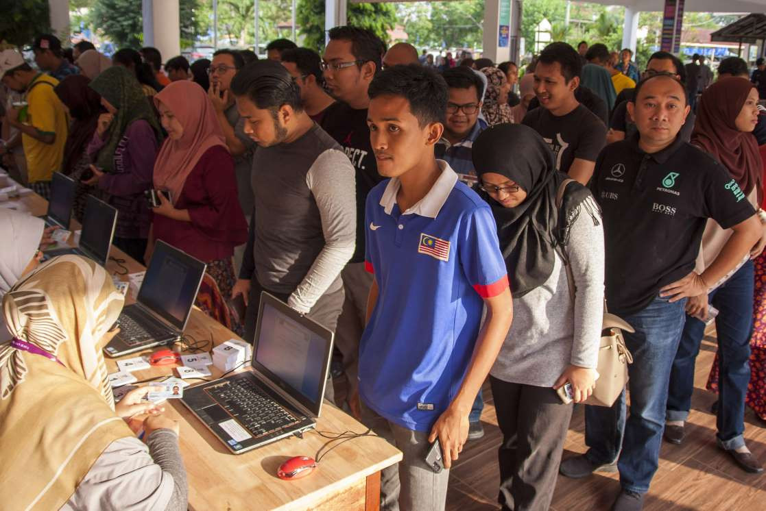 މެއި 9، 2018:މެލޭޝިއާގެ 14 ވަނަ އާންމު އިންތިހާބުގައި ވޯޓުލުމަށް މީހުން ވޯޓިން ބޫތްއެއްގައި ކިޔޫ ހަދާފައި