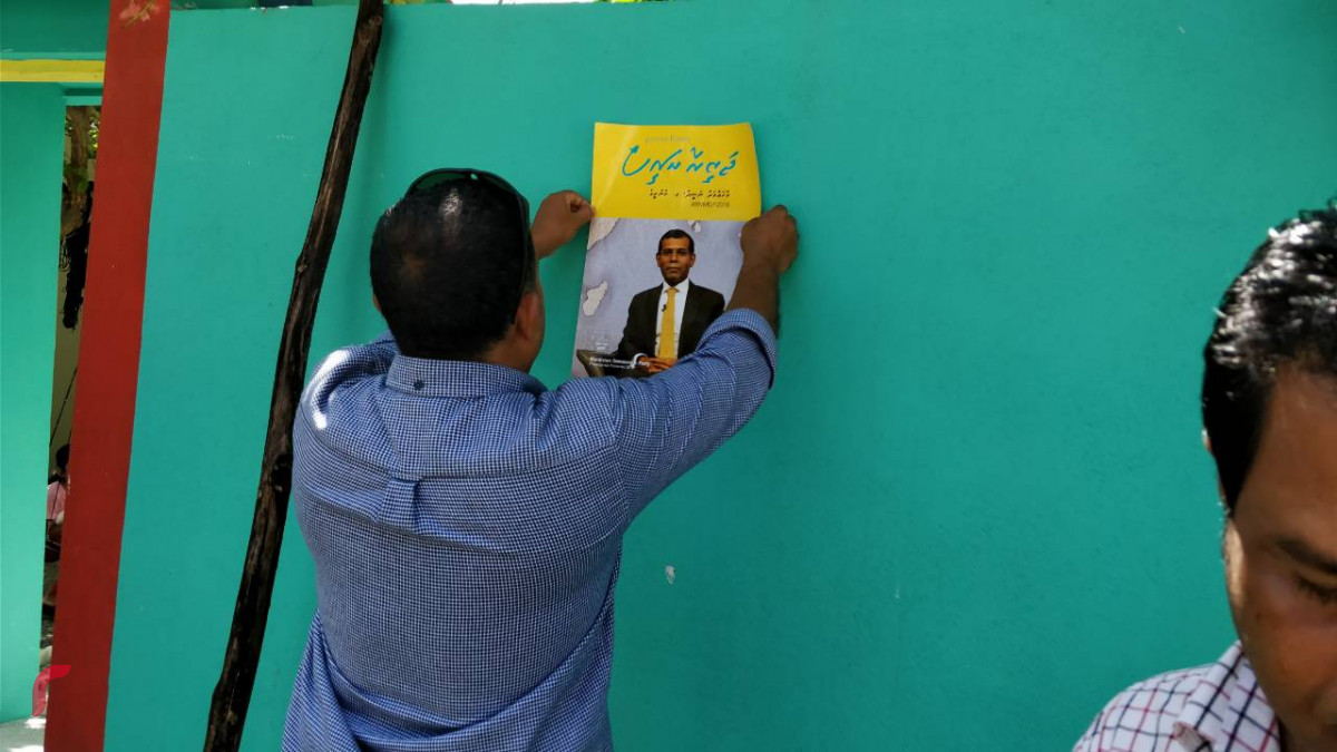 މެއި 18، 2018: ރައީސް ނަޝީދު "ޖަޒީރާ ރައީސް"ގެ ނަމުގައި ރިޔާސީ އިންތިހާބަށް ކުރައްވަމުން ގެންދަވާ ކެމްޕެއިންގެ ތެރެއިން ގދ. މަޑަވެލީގައި ކެމްޕެއިން ޕޯސްޓަރު ހަރުކުރަނީ، މި ދަތުރުގައި ހުވަދޫ އަތޮޅުގެ ގިނަ ރަށްތަކަށް ދިއުމަށް ވަނީ ހަމަޖެހިފައި -- ފޮޓޯ: ރާއްޖެ އެމްވީ