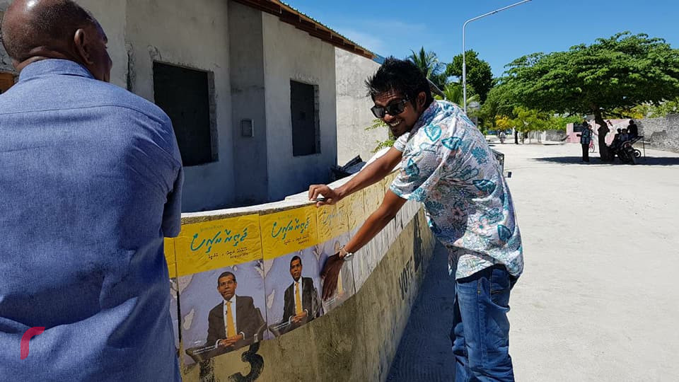 މެއި 18، 2018: ރައީސް ނަޝީދު "ޖަޒީރާ ރައީސް"ގެ ނަމުގައި ރިޔާސީ އިންތިހާބަށް ކުރައްވަމުން ގެންދަވާ ކެމްޕެއިންގެ ތެރެއިން ގއ. ދެއްވަދޫގައި ކެމްޕެއިން ޕޯސްޓަރު ހަރުކުރަނީ، މި ދަތުރުގައި ރައީސް ނަޝީދުގެ ޓީމް ހުވަދު އަތޮޅުގެ ގިނަ ރަށްތަކަށް ދިއުމަށް ވަނީ ހަމަޖެހިފައި -- ފޮޓޯ: ރާއްޖެ އެމްވީ