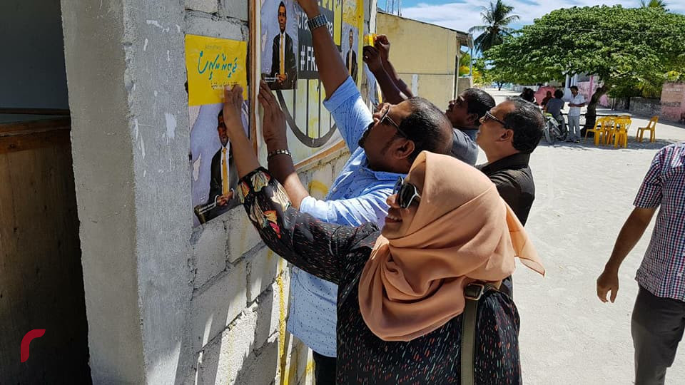 މެއި 18، 2018: ރައީސް ނަޝީދު "ޖަޒީރާ ރައީސް"ގެ ނަމުގައި ރިޔާސީ އިންތިހާބަށް ކުރައްވަމުން ގެންދަވާ ކެމްޕެއިންގެ ތެރެއިން ގއ. ދެއްވަދޫގައި ކެމްޕެއިން ޕޯސްޓަރު ހަރުކުރަނީ، މި ދަތުރުގައި ރައީސް ނަޝީދުގެ ޓީމް ހުވަދު އަތޮޅުގެ ގިނަ ރަށްތަކަށް ދިއުމަށް ވަނީ ހަމަޖެހިފައި -- ފޮޓޯ: ރާއްޖެ އެމްވީ