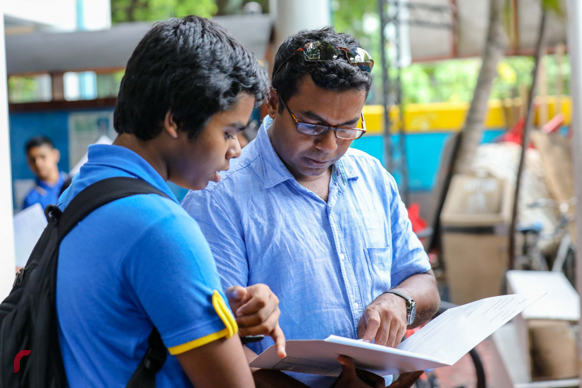 ޖޫން 7، 2018: ބިލަބޮންގް އިންޓަރނޭޝަލް ސްކޫލްގެ ދަރިވަރަކު އޭނާގެ ބެލެނިވެރިޔާ އާއި އެކު ސެމިސްޓަރގެ ނަތީޖާ އާއި މެދު މަޝްވަރާ ކުރަނީ -- ފޮޓޯ: މުހައްމަދު ޝަރުހާން