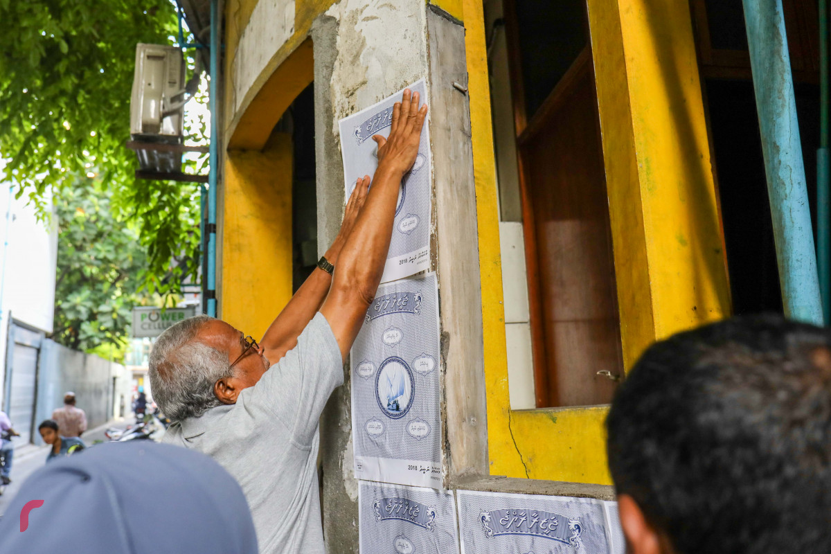 ޖޫން 25، 2018: އެމްޑިޕީއިން "ޖަޒީރާ ރާއްޖެ" ކެމްޕެއިން ޕޯސްޓަރު ހަރުކުރުމަށް ކުރިއަށްގެންދިޔަ ހަރަކާތުގެ ތެރެއިން ގެއެއްގެ ފާރުގައި ޕޯސްޓަރު ހަރުކުރަނީ، މި ހަރަކާތުގައި މާލޭގެ އެކި ސަރަހައްދުތަކުގައި ޕޯސްޓަރު ހަރުކުރުން ވަނީ ކުރިއަށްގެންގޮސްފައި -- ފޮޓޯ: މުހައްމަދު ޝަރުހާން / ރާއްޖެ އެމްވީ