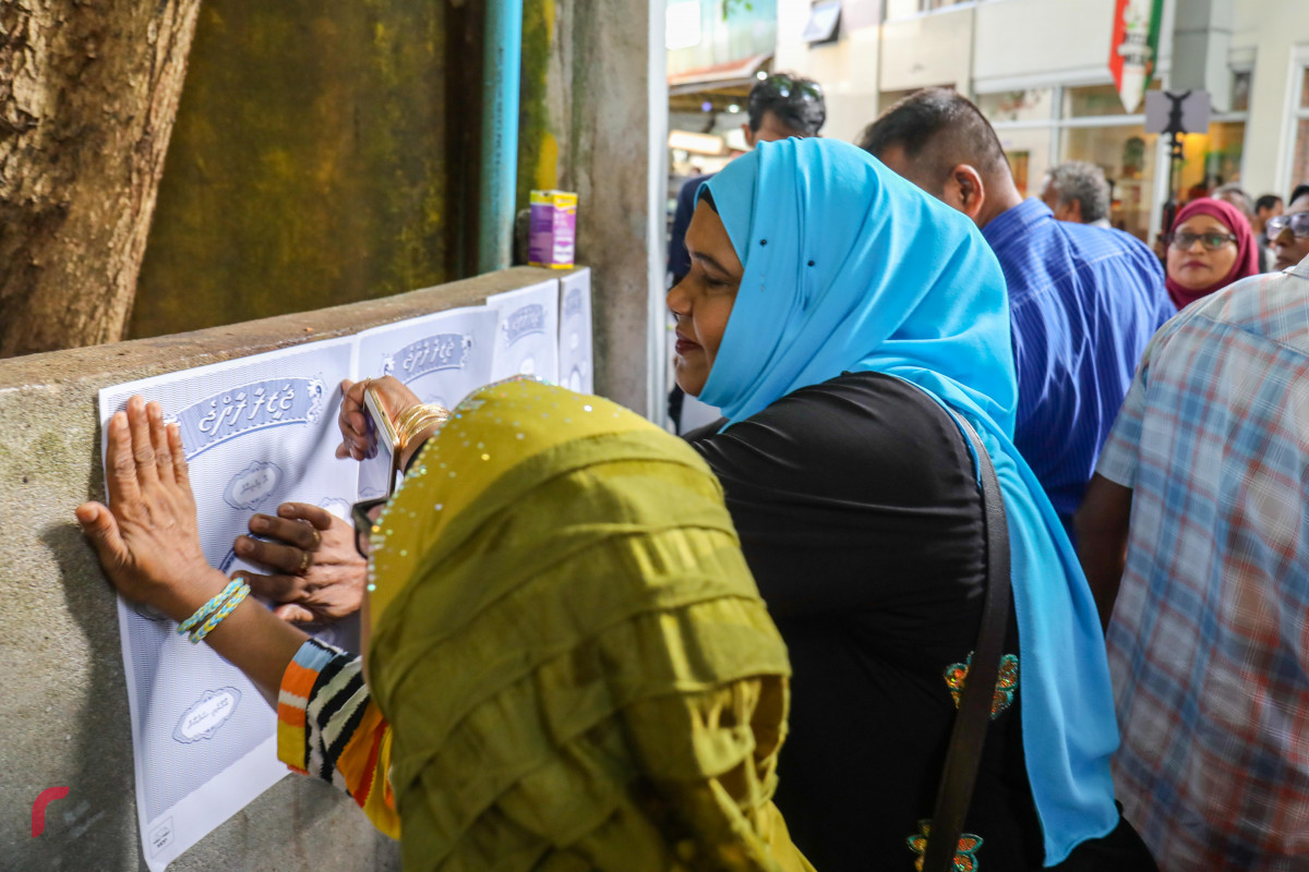 ޖޫން 25، 2018: އެމްޑިޕީއިން "ޖަޒީރާ ރާއްޖެ" ކެމްޕެއިން ޕޯސްޓަރު ހަރުކުރުމަށް ކުރިއަށްގެންދިޔަ ހަރަކާތުގެ ތެރެއިން ގެއެއްގެ ފާރުގައި ޕޯސްޓަރު ހަރުކުރަނީ، މި ހަރަކާތުގައި މާލޭގެ އެކި ސަރަހައްދުތަކުގައި ޕޯސްޓަރު ހަރުކުރުން ވަނީ ކުރިއަށްގެންގޮސްފައި -- ފޮޓޯ: މުހައްމަދު ޝަރުހާން / ރާއްޖެ އެމްވީ